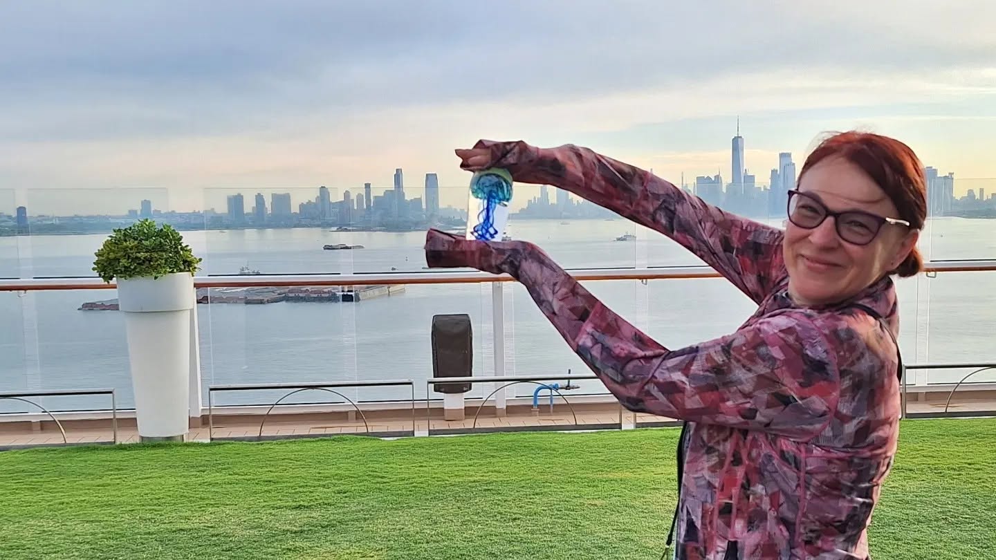 Edina holding the glass artwork she created aboard Celebrity Eclipse